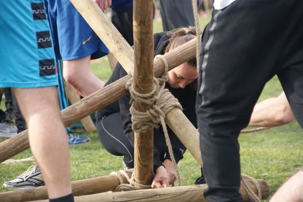 Team bouwt brug boven het zwembad tijdens een originele vergaderbreak op een landelijke trainingslocatie